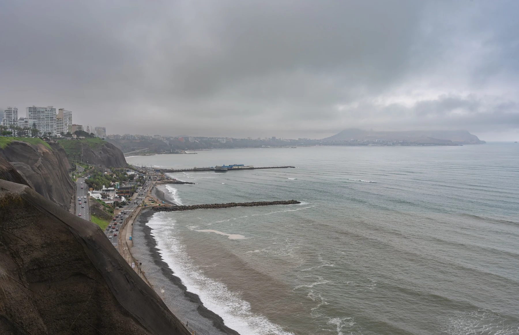 The cliffs and Pacific shoreline of Miraflores under overcast skies, photographed in July 2024
